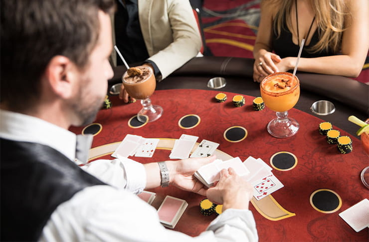 A croupier dealing cards to players.